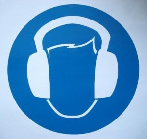 Man wearing ear mufflers against noise pollution