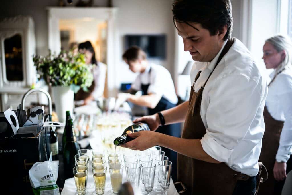 Man Pouring Wine on Glasses after receiving food safety awareness course